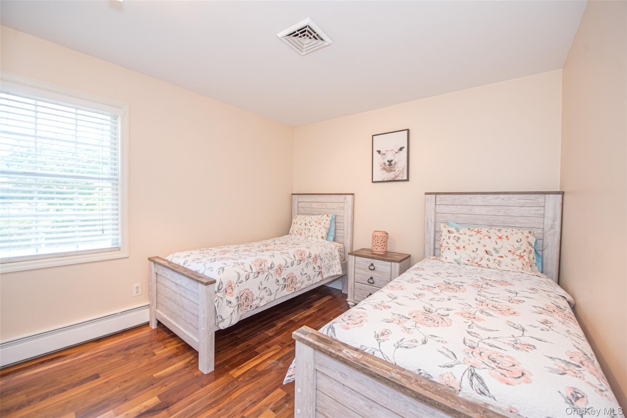 63 East Tiana Road Hampton Bays, NY 11946 - Photo 23 of 30 a bedroom with two beds and a window