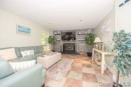 63 East Tiana Road Hampton Bays, NY 11946 - Photo 7 of 30 a living room with furniture and a fireplace