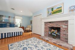 608 Old Post Road Cotuit, MA 02635 - Photo 8 of 30 a bedroom with a bed and a fireplace
