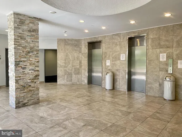 a view of a hallway with wooden cabinets