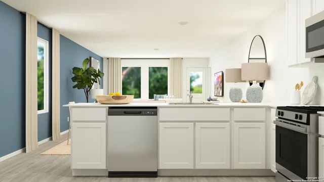a kitchen with white cabinets and sink