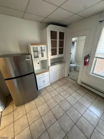 a room with a chair and a refrigerator