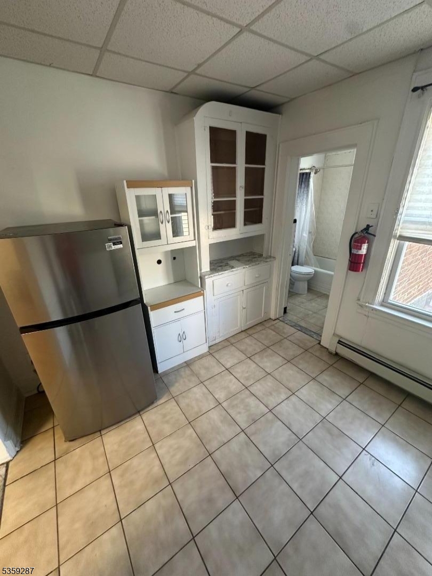 1153 Main Avenue Clifton, NJ 07011 - Photo 6 of 6 a room with a chair and a refrigerator