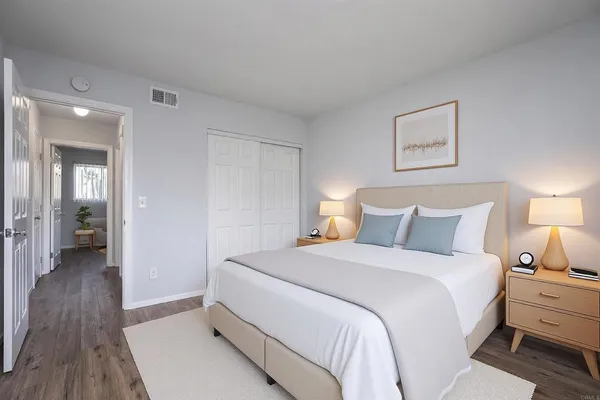 a bedroom with a bed and a painting on the wall