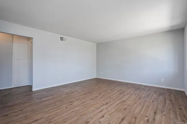 a view of an empty room with wooden floor