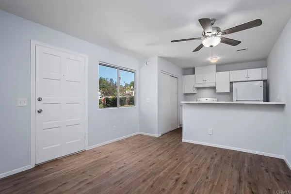 a view of a kitchen with wooden floor and a ceiling fan