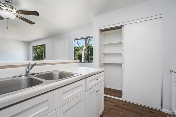 a kitchen with a sink and wooden floor