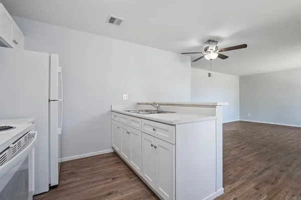 a view of a kitchen with a stove and wooden floor