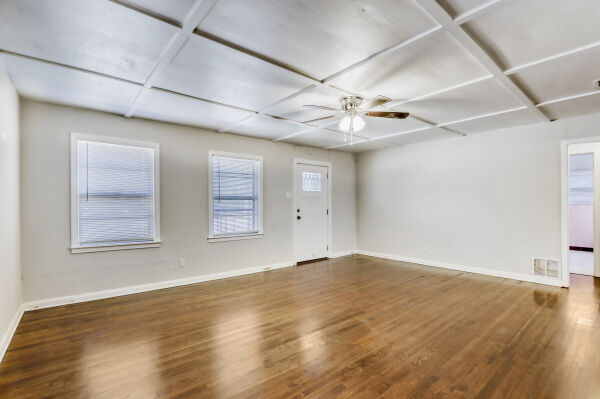 607 West N Loop Boulevard Austin, TX 78751 - Photo 4 of 11 an empty room with wooden floor fan and windows