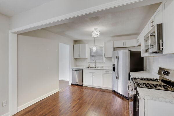 607 West N Loop Boulevard Austin, TX 78751 - Photo 5 of 11 a kitchen with stainless steel appliances a refrigerator a stove a sink cabinets and wooden floor