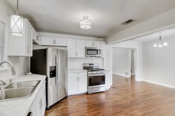 a kitchen with stainless steel appliances a refrigerator sink and microwave