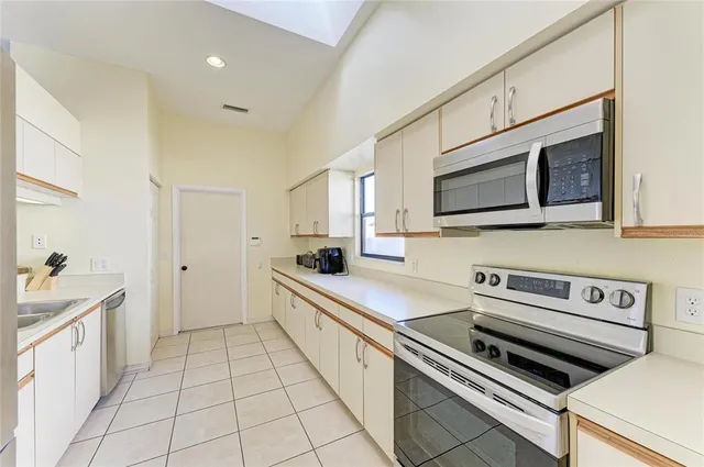 a kitchen with stainless steel appliances a sink cabinets and microwave