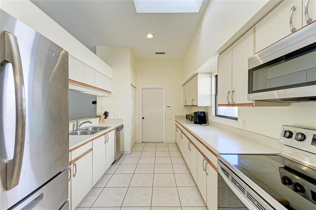 5045 82nd Way East Sarasota, FL 34243 - Photo 12 of 34 a kitchen with a sink and white cabinets