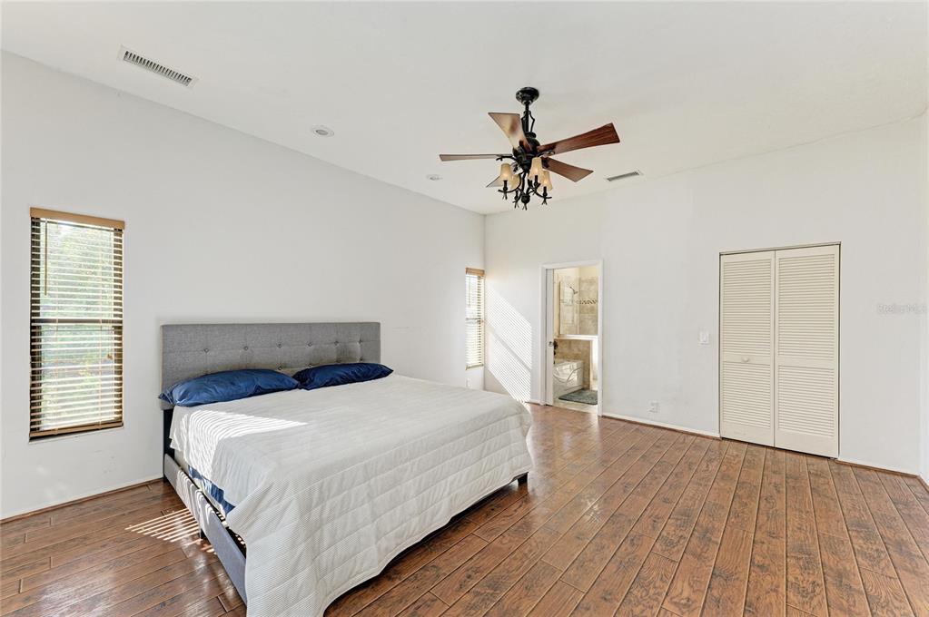 5045 82nd Way East Sarasota, FL 34243 - Photo 18 of 34 a bedroom with a bed and wooden floor