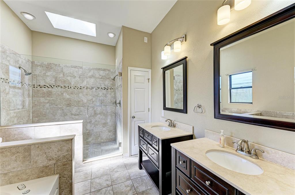 5045 82nd Way East Sarasota, FL 34243 - Photo 19 of 34 a spacious bathroom with a sink a toilet and shower