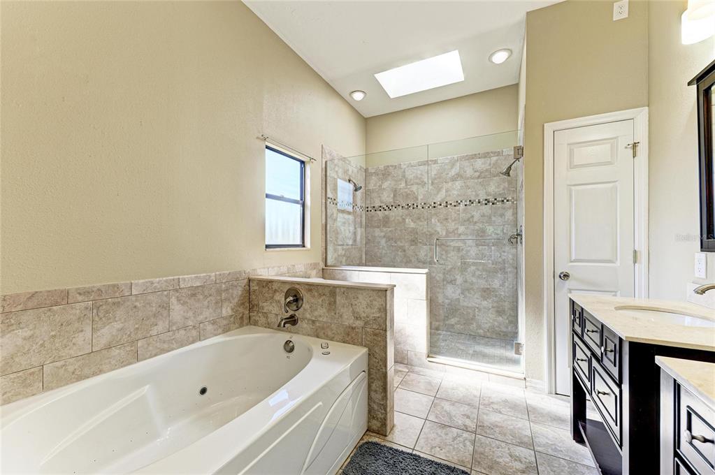 5045 82nd Way East Sarasota, FL 34243 - Photo 21 of 34 a bathroom with a tub a sink and a shower