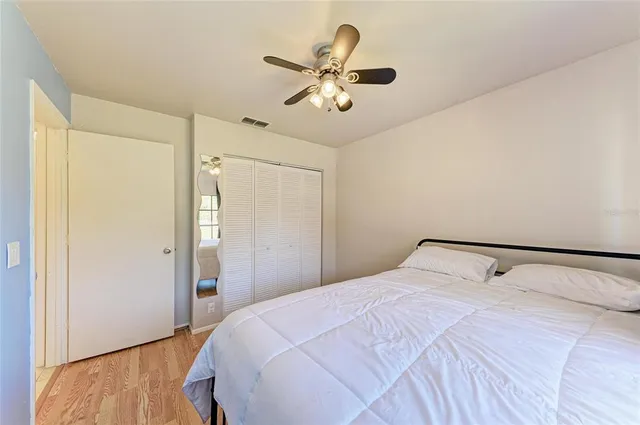 a bedroom with a large bed and a ceiling fan