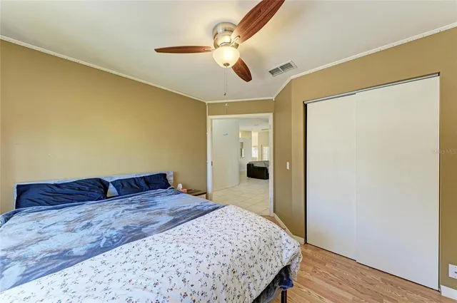 a bedroom with a large bed and wooden floor