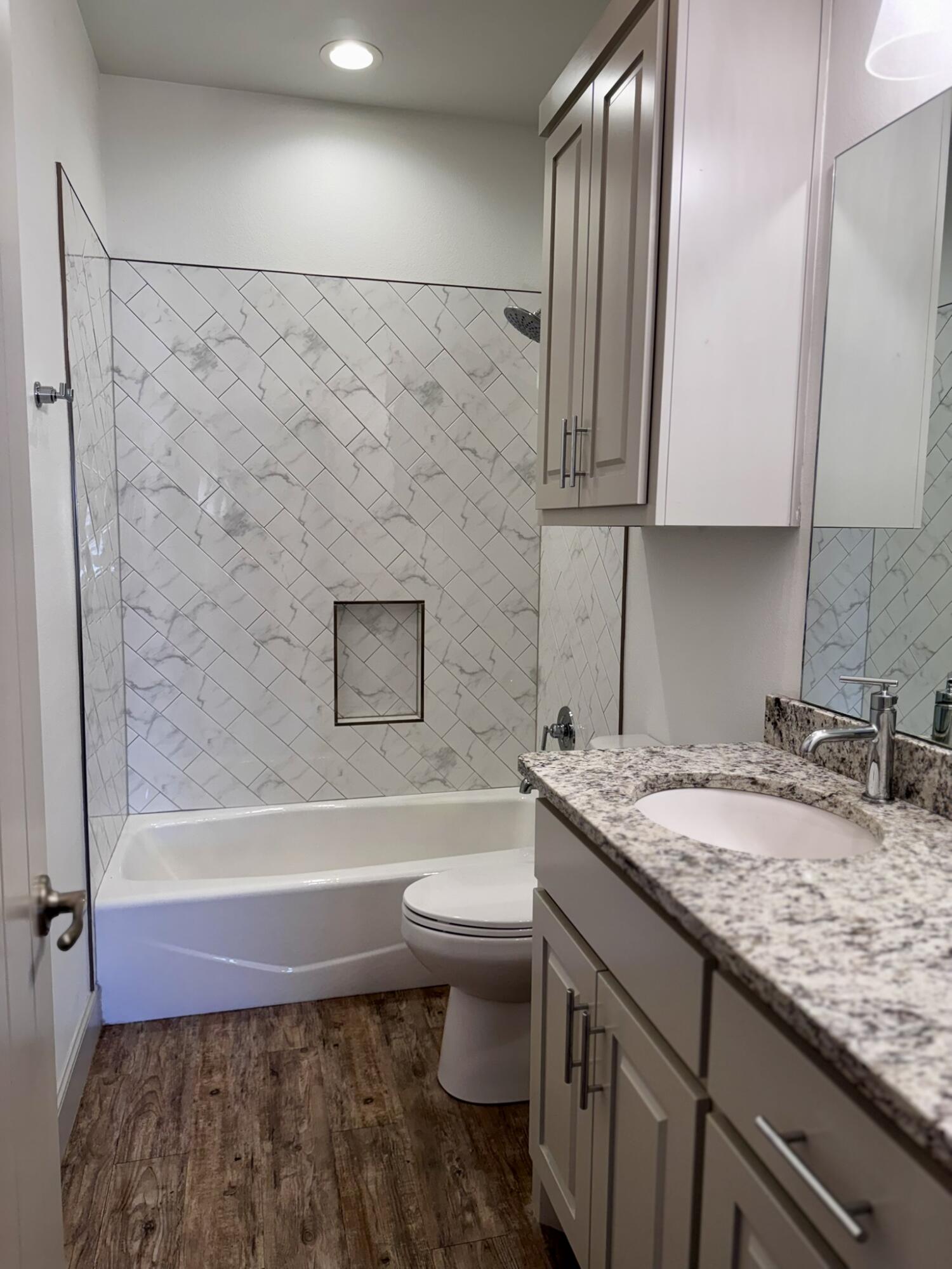 5615 115th Street Lubbock, TX 79424 - Photo 22 of 31 a bathroom with a granite countertop sink toilet and shower