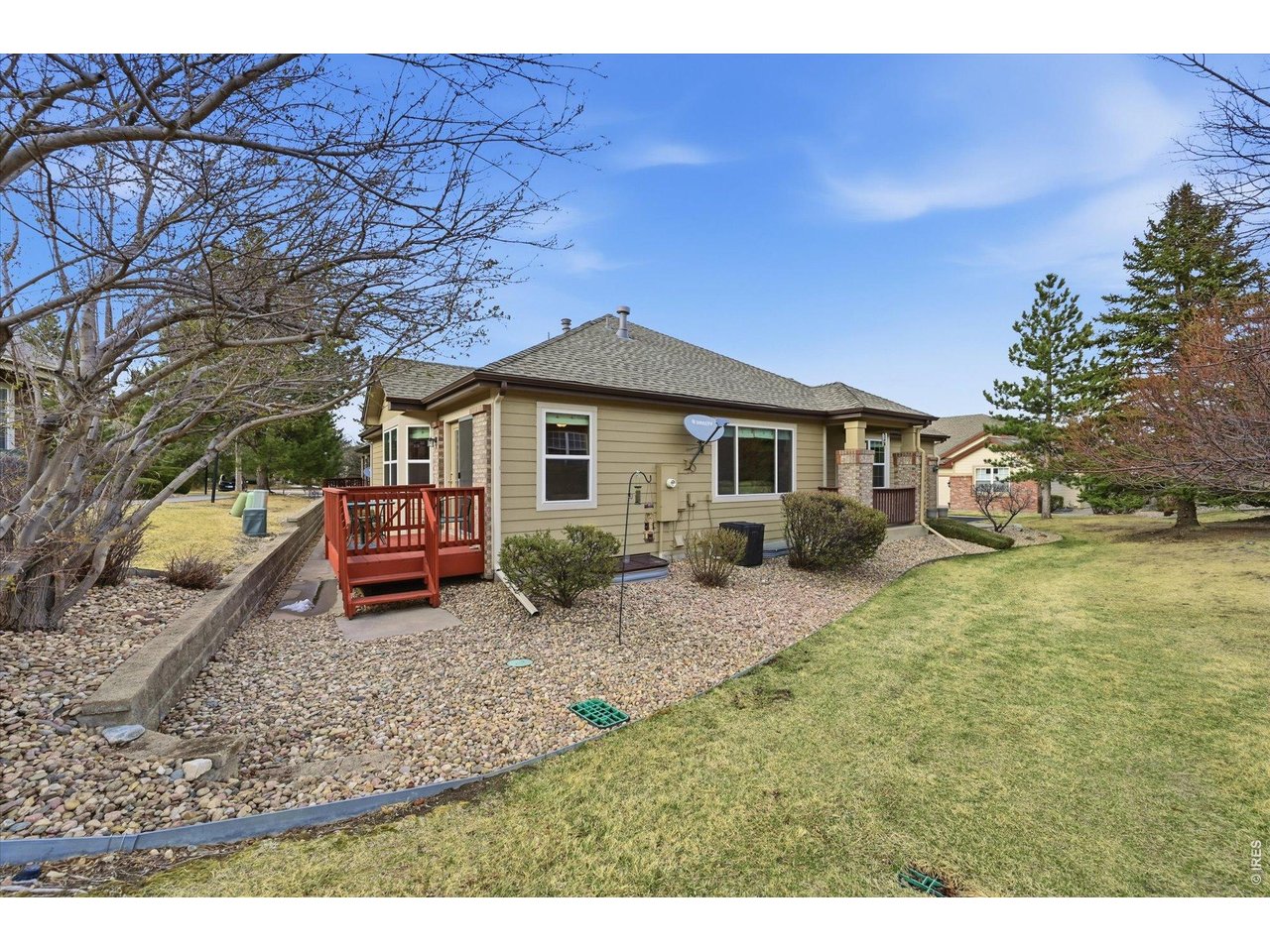 6227 Secrest Lane Arvada, CO 80403 - Photo 22 of 47 a white house that has a small yard and large trees