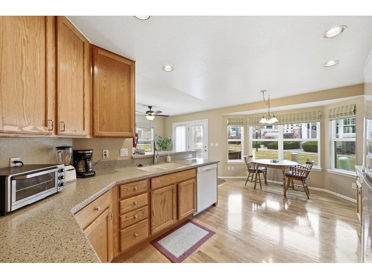 6227 Secrest Lane Arvada, CO 80403 - Photo 27 of 47 a large white kitchen with granite countertop a large window