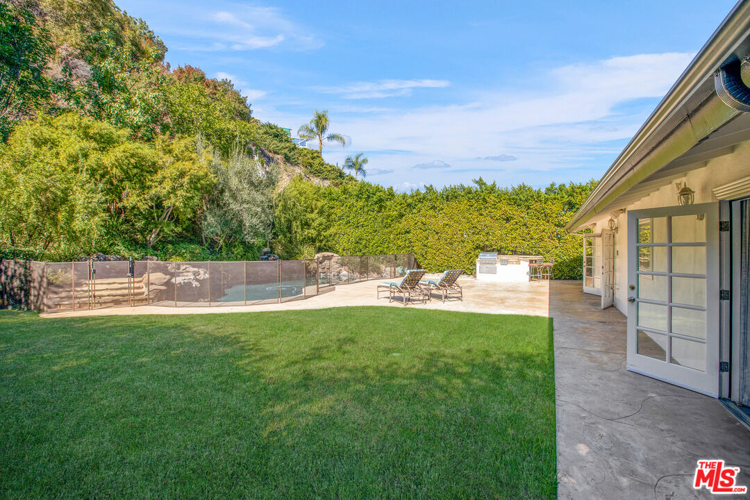 16636 Calneva Drive Encino, CA 91436 - Photo 16 of 18 a backyard of a house with table and chairs