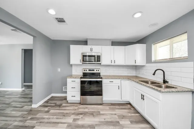 a kitchen with stainless steel appliances granite countertop a stove sink and cabinets