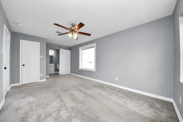 a view of a livingroom with a ceiling fan and window