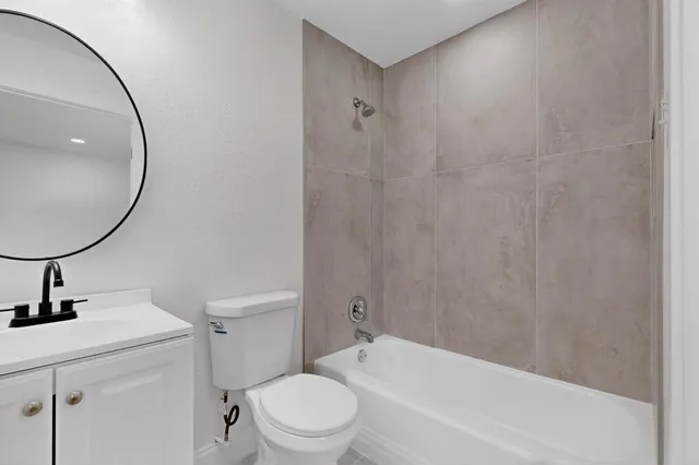 a bathroom with a bathtub a sink a toilet and a mirror