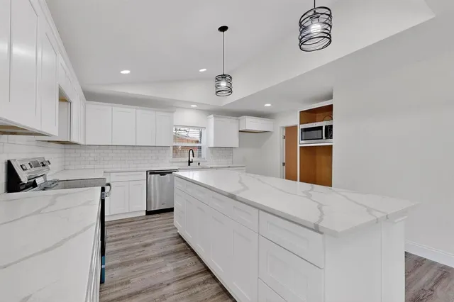 a kitchen with a stove cabinets and wooden floor
