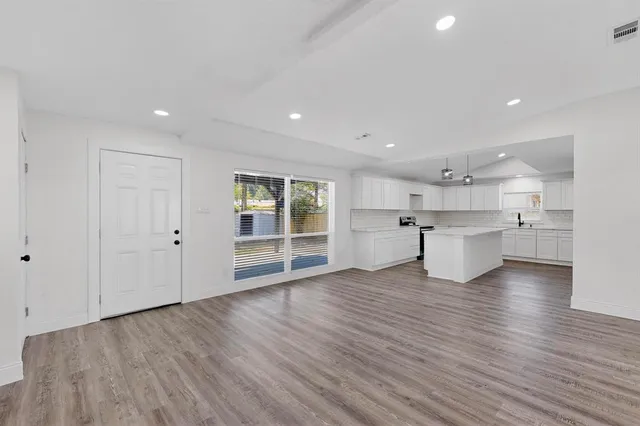 a view of an empty room with wooden floor