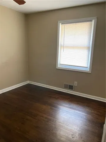 an empty room with wooden floor and a window