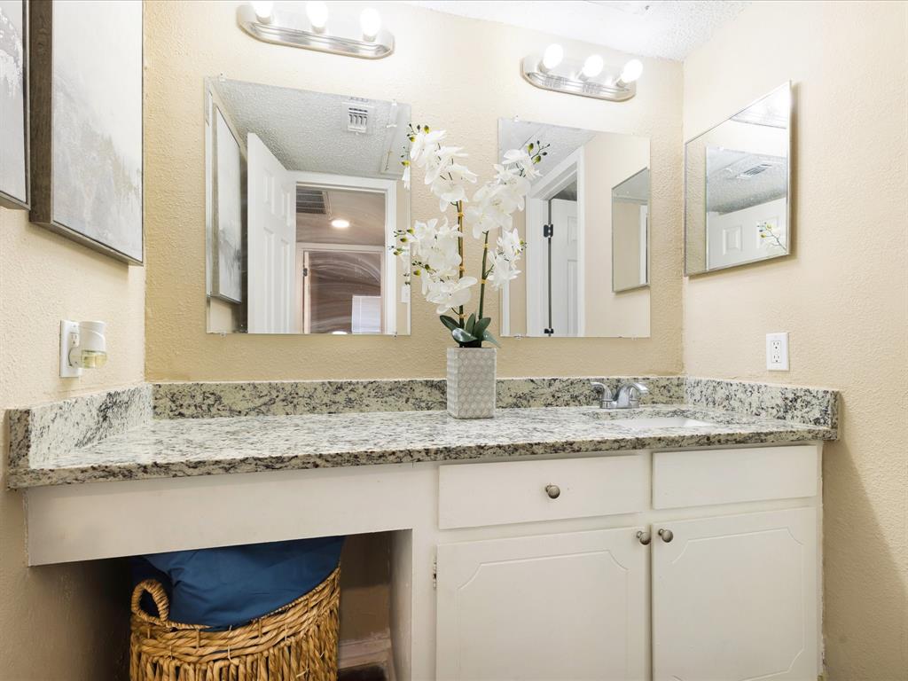 5532 Boca Raton Boulevard, Unit 191 Fort Worth, TX 76112 - Photo 6 of 7 a bathroom with a granite countertop sink a toilet and a mirror