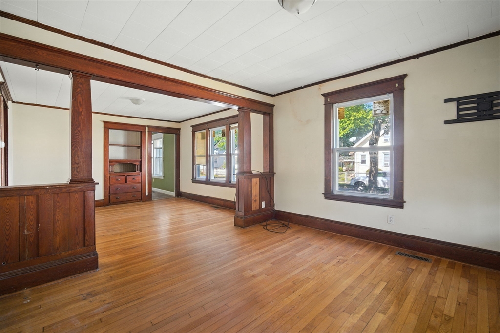 56-58 Phoenix Street Springfield, MA 01104 - Photo 4 of 29 a view of an empty room with wooden floor and a window
