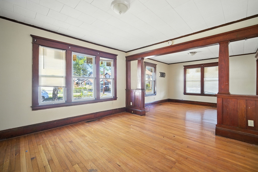 56-58 Phoenix Street Springfield, MA 01104 - Photo 5 of 29 a view of an empty room with wooden floor and a window