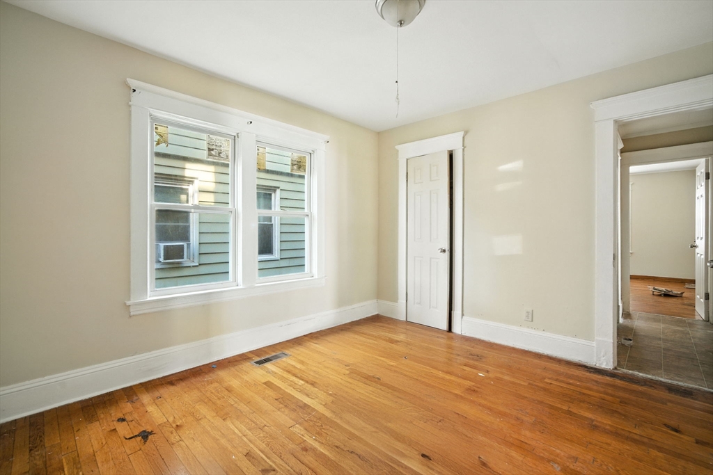 56-58 Phoenix Street Springfield, MA 01104 - Photo 8 of 29 a view of an empty room with wooden floor and a window