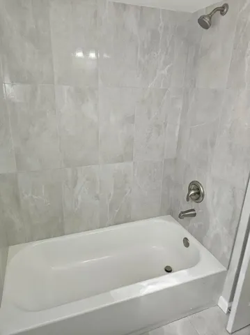 a view of an empty room with wooden floor and window