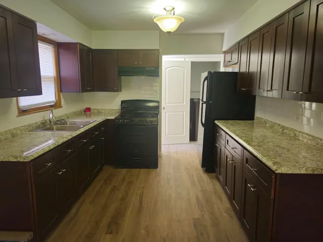 a kitchen with granite countertop stainless steel appliances and wooden cabinets