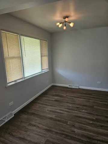 a view of a room with a ceiling fan and wooden floor