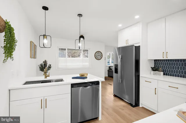 a kitchen with kitchen island white cabinets and refrigerator
