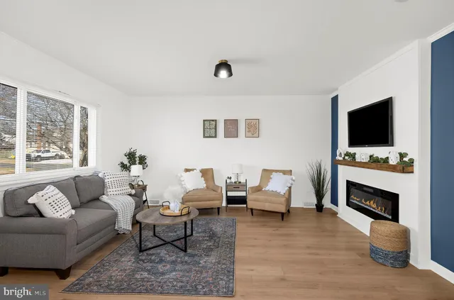 a living room with furniture a fireplace and a flat screen tv