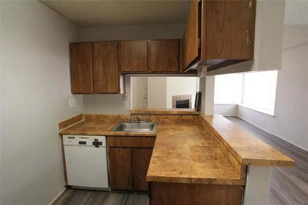 a kitchen with granite countertop a sink a stove and a microwave oven in a cabinets
