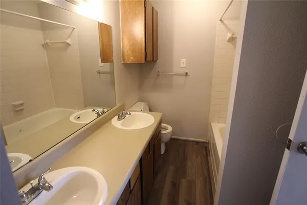 a bathroom with a sink and mirror with toilet