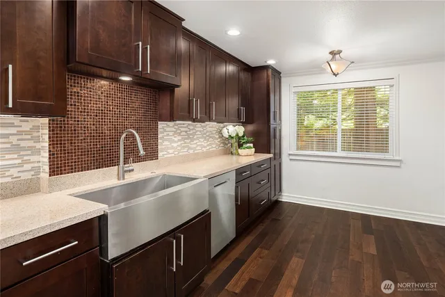 a kitchen with stainless steel appliances wooden cabinets a sink dishwasher a stove and a refrigerator with wooden floor