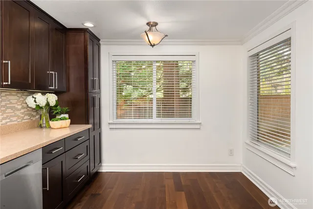 a view of a kitchen with wooden floor and a window