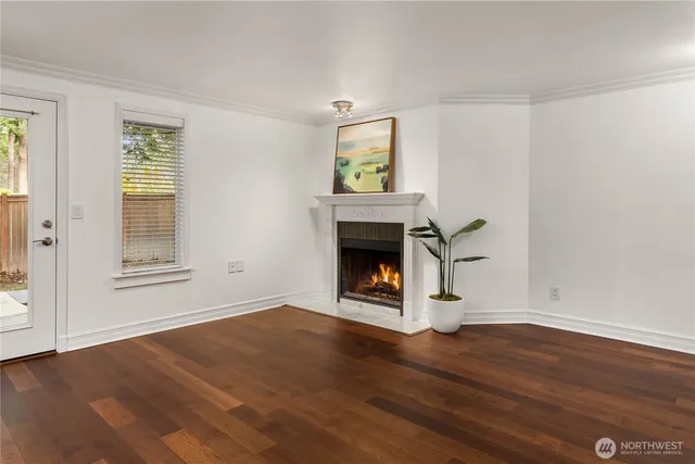 an empty room with wooden floor a fireplace and windows
