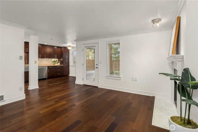 a view of empty room with kitchen and window