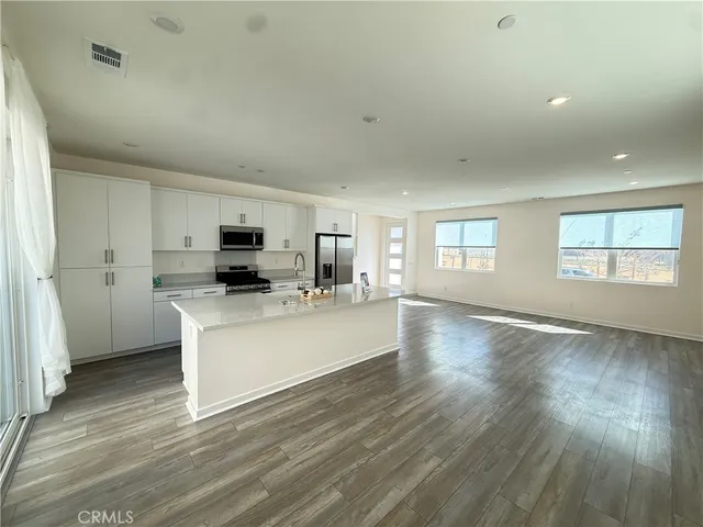 a view of open kitchen with wooden floor and electronic appliances