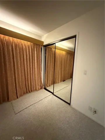 a view of a big room with wooden floor and windows