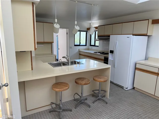 a kitchen with stainless steel appliances a sink a refrigerator a stove a washer and dryer